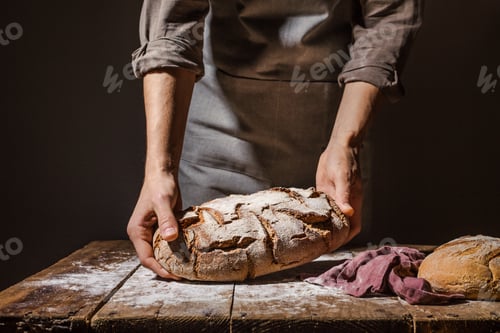 Preview: Baker or chef holding fresh made bread