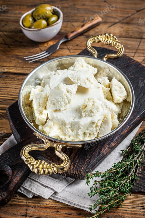 Preview: Goat and sheep cheese in a pan with olives and rosemary. Wooden background. Top view