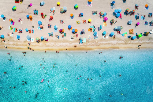 Preview: Aerial view of sandy beach with umbrellas and sea