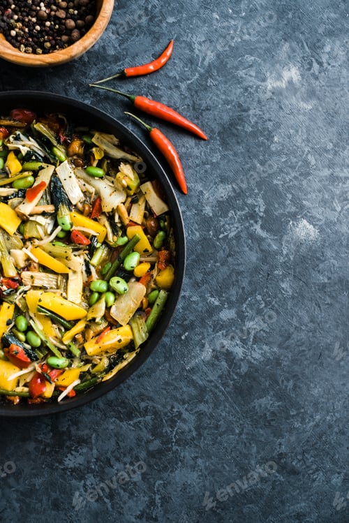 Preview: Fresh asian vegetables mix, Thai wok in a black pan on the black background with copy space