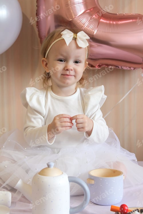 Preview: Baby girl is playing dolls and celebrates her 2nd birthday with colourful balloons. Happy birthday!