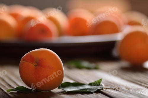 Preview: Clay dish full of ripe apricots on wooden table