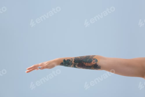 Preview: Female arm with tattoo on color background