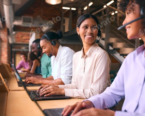 Preview: Multi-Cultural Customer Support Or Telesales Team In Modern Open Plan Office Wearing Headsets