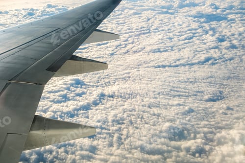 Preview: View from airplane on the aircraft white wing flying over cloudy landscape in sunny morning. Air