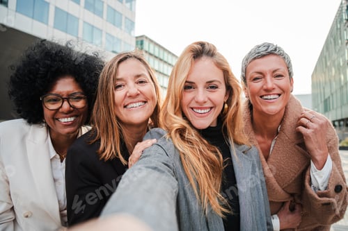 Preview: Group of real successful business woman smiling and having fun taking a selfie portrait together