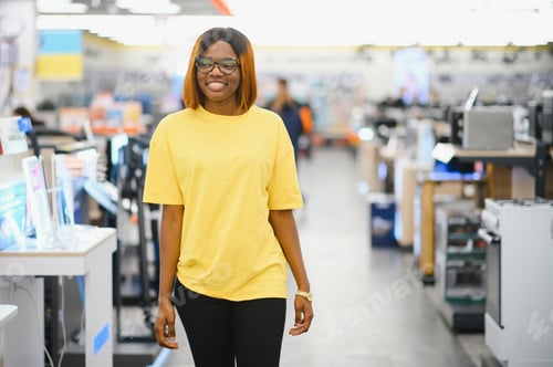 Preview: Portrait of happy African American girl in electronics store. A store of modern household appliances