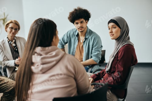 Preview: Multi-ethnic people having counseling during group therapy meeting at community center.