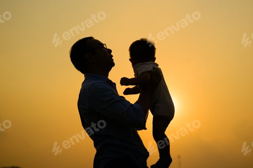 Preview: Happy father holding newborn baby playing together with sunset view