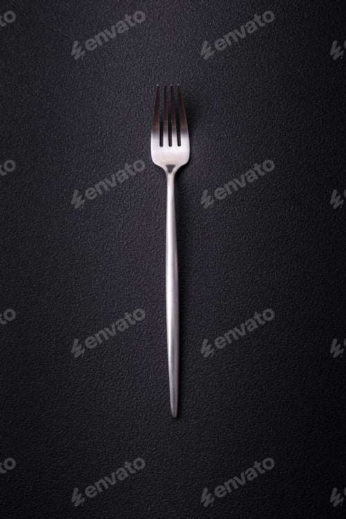 Preview: Metal kitchen fork on a dark textured concrete background