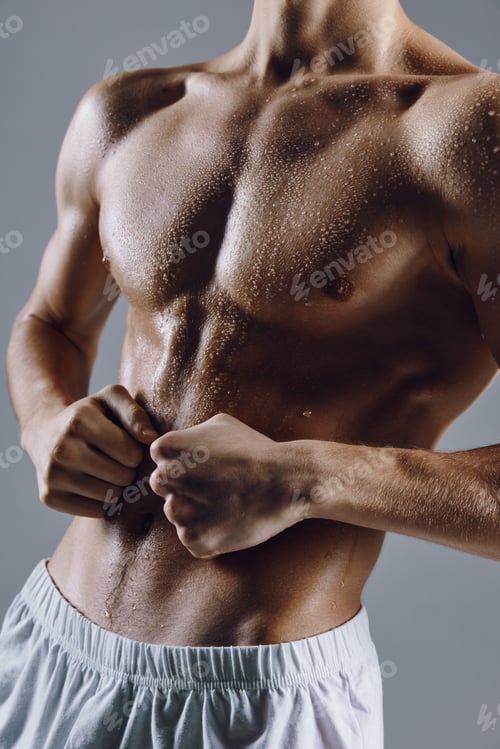 Preview: athlete in white shorts on a gray background gesturing with his hands bodybuilder