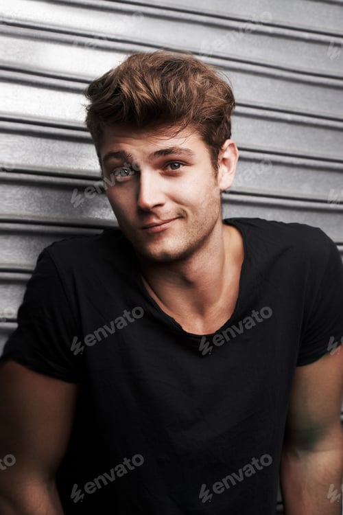 Preview: Hes hasnt a care. Portrait of a handsome young man standing in front of some metal shutters.