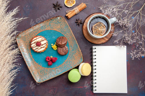 Preview: top view little creamy cake with chocolate cookies and cup of tea on a dark background biscuit cake