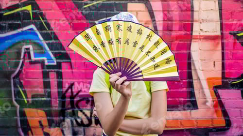Preview: Teenager girl having fun on the street against the background of the wall with graffiti