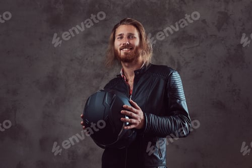 Preview: Portrait of a handsome stylish redhead man in a black leather jacket, posing in a studio