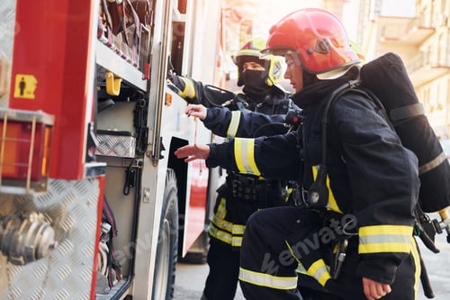 Preview: Group of firefighters in protective uniform that outdoors near truck