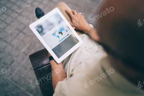 Preview: Cropped image of male holding touch pad downloading location map via application