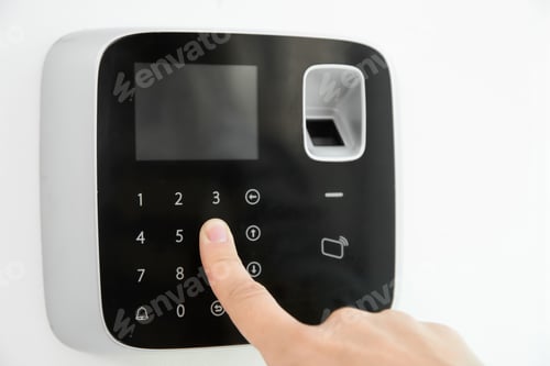 Preview: Young woman entering code on alarm system keypad indoors