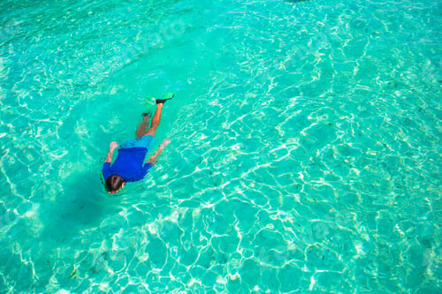 Preview: Young man snorkeling in clear tropical turquoise waters
