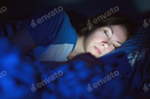 Preview: girl sleeping in the evening at home on the bed under the covers with the phone