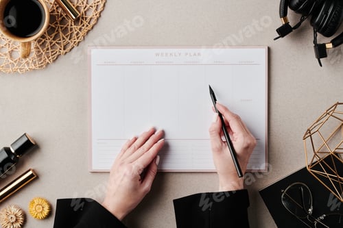 Preview: Overview of hands of businesswoman with pen over open planner by workplace