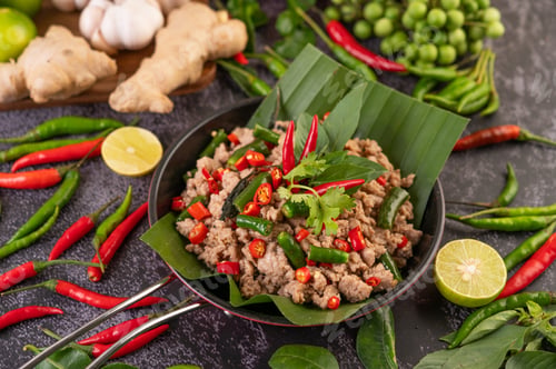 Preview: Stir-fried pork basil on banana leaves in a frying pan.