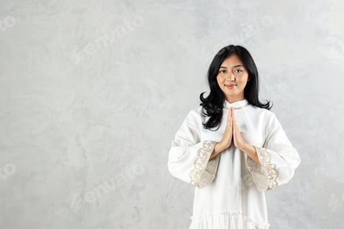 Preview: Female Asian Muslim Wearing White Abaya Gesturing Eid Mubarak Greeting
