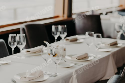 Preview: Served dinner table with glasses and cutlery on white table-wear in luxury banquet with no people