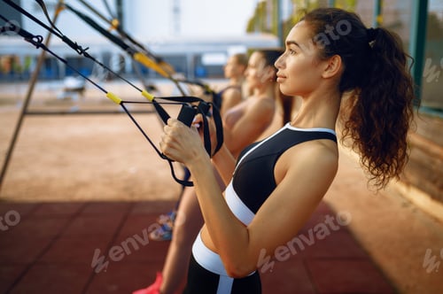 Preview: Slim women doing exercise, outdoors group training