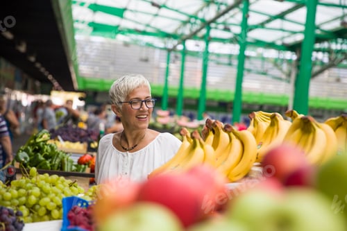 Preview: Portrait of senior woman buys bananas at the market