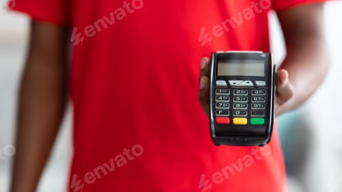 Preview: Cropped view of black man holding POS machine for payment