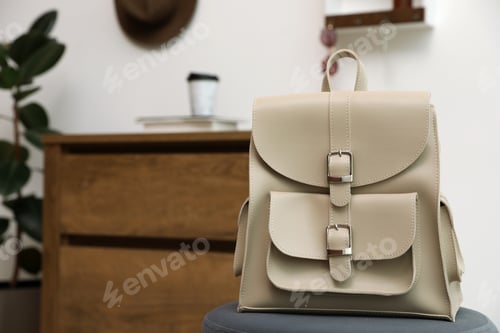 Preview: Stylish urban backpack on stool in hallway. Space for text