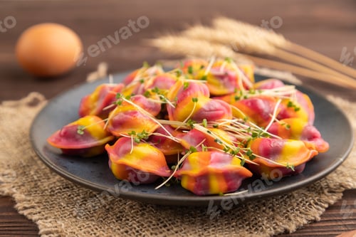 Preview: Rainbow colored dumplings with microgreen on brown wooden. Side view, selective focus