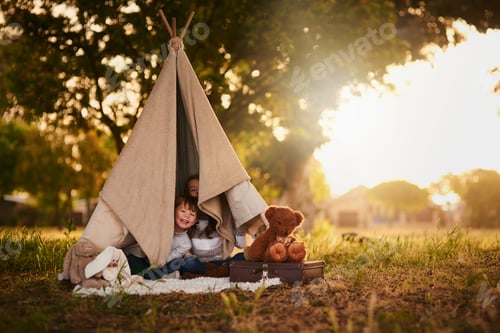 Preview: Halt Who goes there. Portrait of two cute little siblings playing together in a teepee outside.