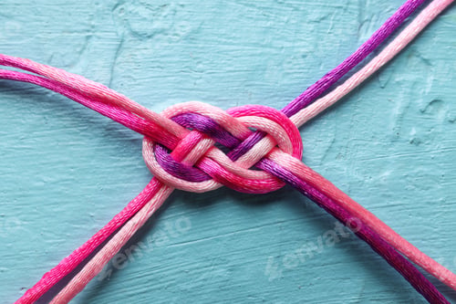 Preview: Braided cords tied together in the shape of an infinity sign on a blue background