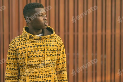 Preview: Young black African man thinking against wooden gate