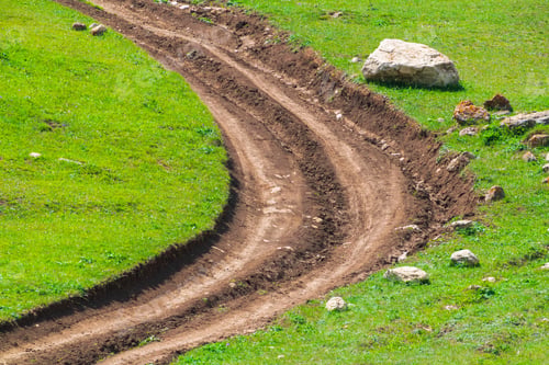 Preview: Winding dirt road among green field