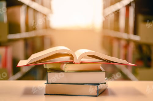 Preview: Opened book with stack of books on the desk wood in the library. Education background concept.
