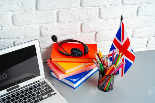 Preview: Laptop and flag of UK on desk. English language learning concept