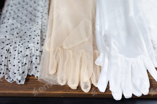 Preview: Close-up of a large selection of gloves for the bride made of a thin veil in the wedding salon.