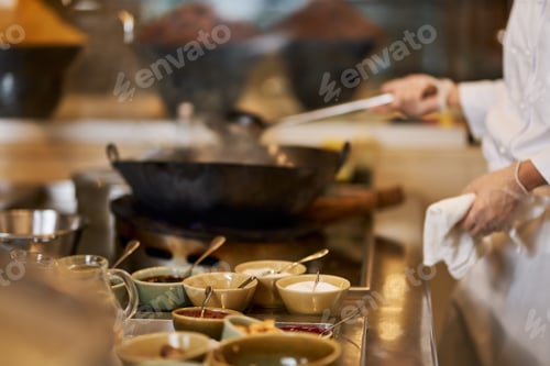 Preview: Fragment photo of chef putting more ingredients into wok