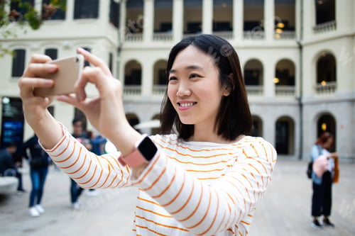 Preview: Happy tourist taking selfie on street