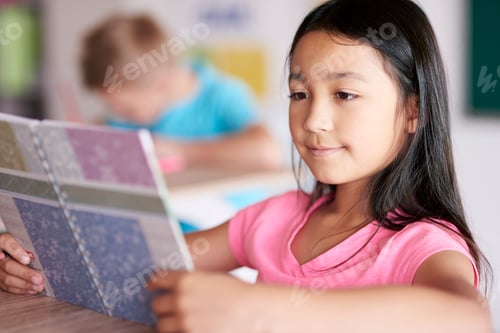 Preview: Close up of mixed race girl reading book