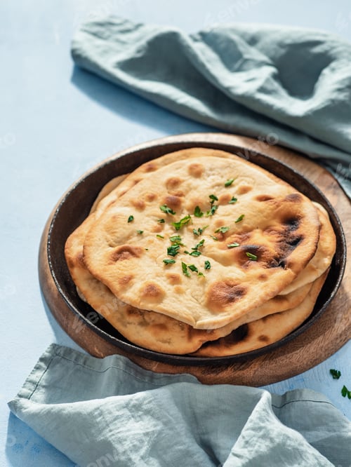 Preview: naan flatbread on blue, copy space, vertical