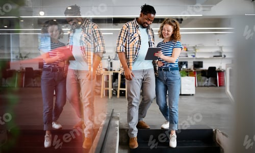 Preview: Colleagues discussing business and smiling while walking through the office corridor