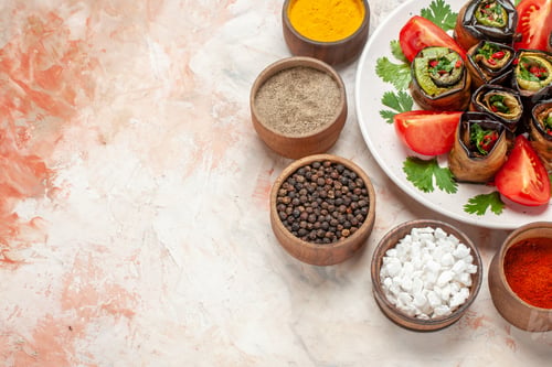 Preview: top view tasty eggplant rolls with greens tomatoes and seasonings on light background cuisine color