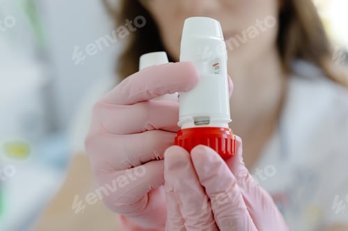 Preview: Female doctor holding and showing asthma inhaler. Medical portable equipment for asthma attack