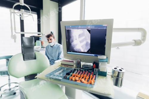 Preview: Dental x-ray on computer screen, dentist in background