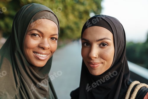 Preview: Multiracial muslim women smiling while walking together