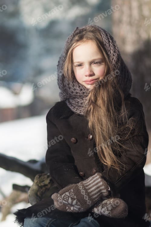 Visualização: Linda garotinha caucasiana vestindo casaco e xale de pele ao lado da árvore ao ar livre em um dia frio de inverno